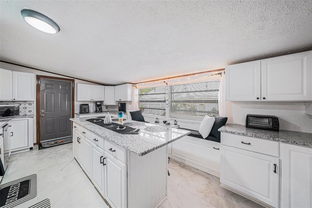 Updated kitchen w/a breakfast bar, granite counters,new stainless steel appliances, new tile flooring & new cabinets