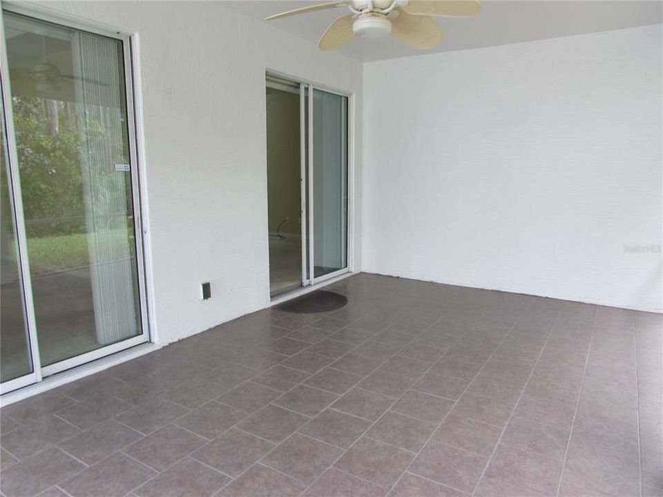 Screened lanai with sliders to the living room and primary bedroom