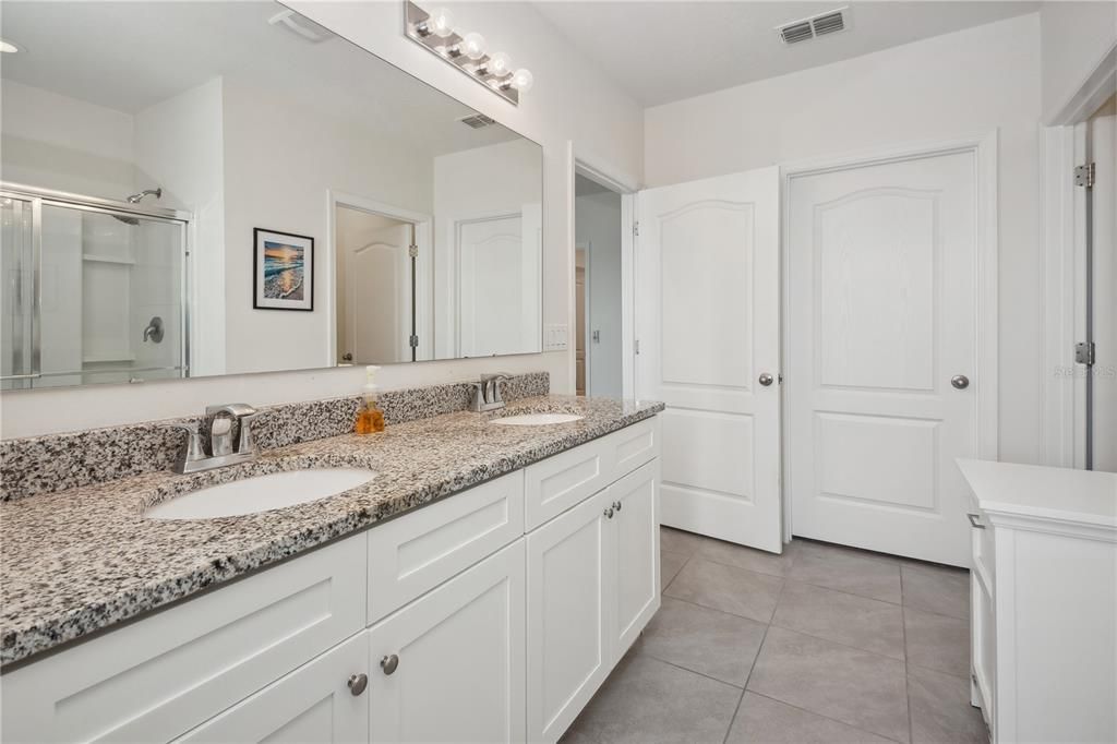 Primary Bathroom with dual sinks and two walk in closets