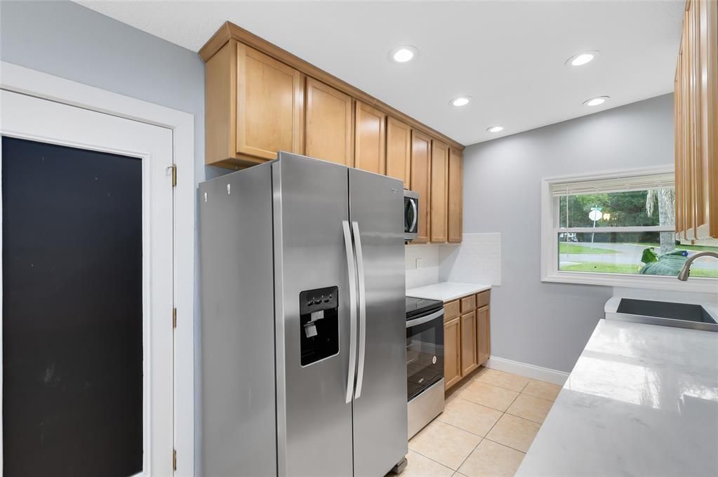 Galley kitchen with White Quartz Countertops and Tile Backsplash. 42" cabinets Brand New Appliances and stainless steel sink