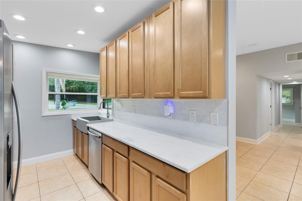 Galley kitchen with White Quartz Countertops and Tile Backsplash. 42" cabinets Brand New Appliances and stainless steel sink