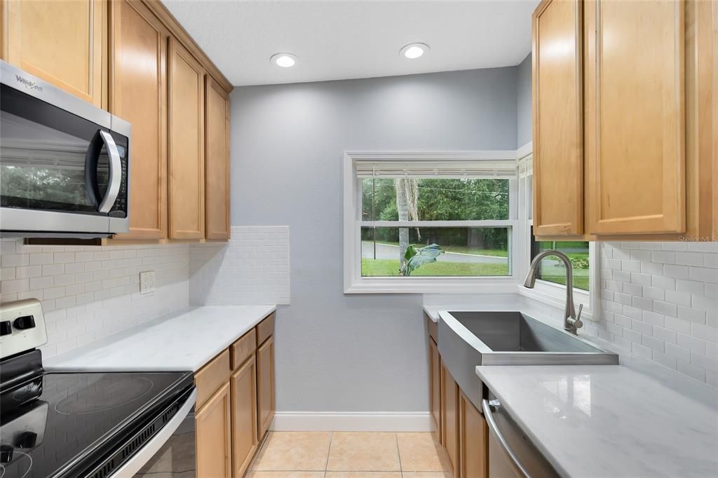 Galley kitchen with White Quartz Countertops and Tile Backsplash. 42" cabinets Brand New Appliances and stainless steel sink