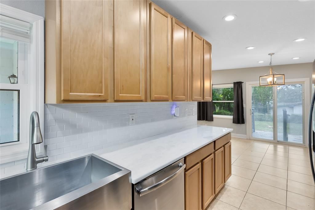 Galley kitchen with White Quartz Countertops and Tile Backsplash. 42" cabinets Brand New Appliances and stainless steel sink