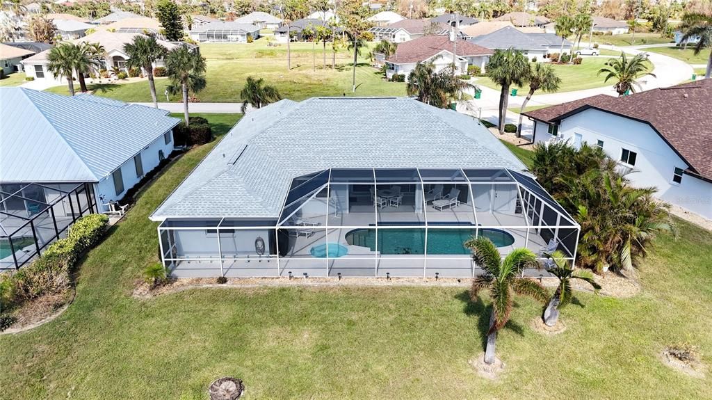 Back of the house showing a large heated pool and spa with lots of space for lounging plus shade under the roof.