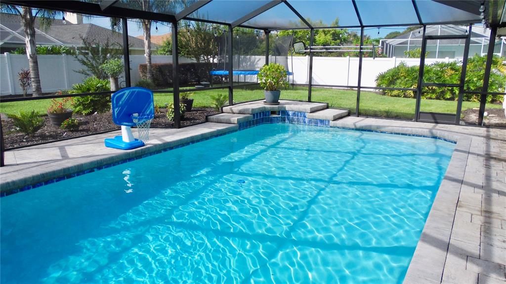 screen pool area with waterfall and updated pavers