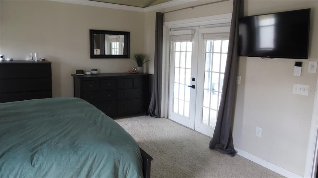 primary bedroom has french doors leading to pool area.