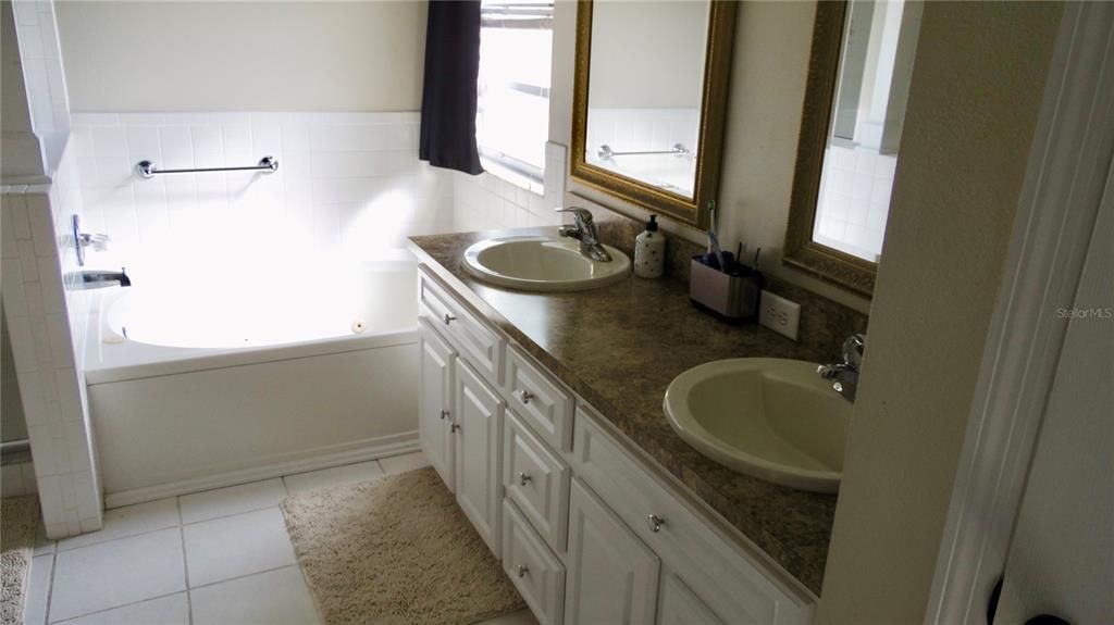 Primary bedroom has double vanity and large separate tub