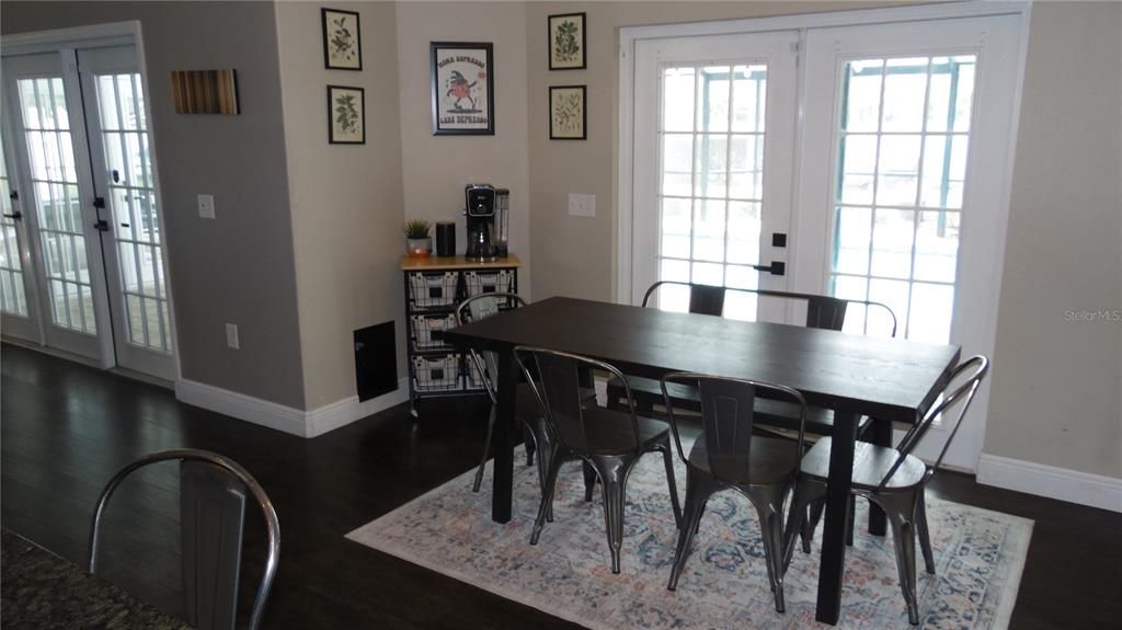 Eating space in kitchen overlooks pool and connects to family room and kitchen