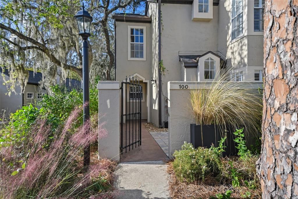 Gated entry leads to courtyard finished with pavers.