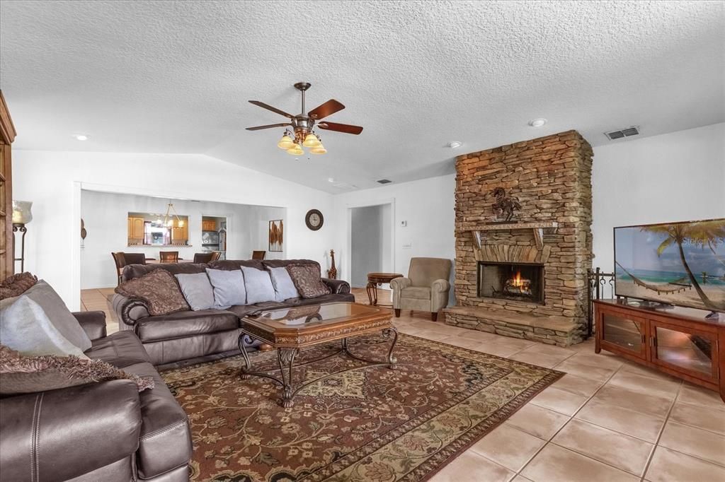 Large living room/family room with wood burning fireplace, vaulted ceilings and views of Lake Arnold!