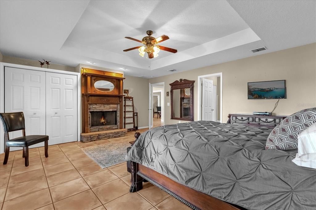 Main primary bedroom with views of Lake Arnold and fireplace