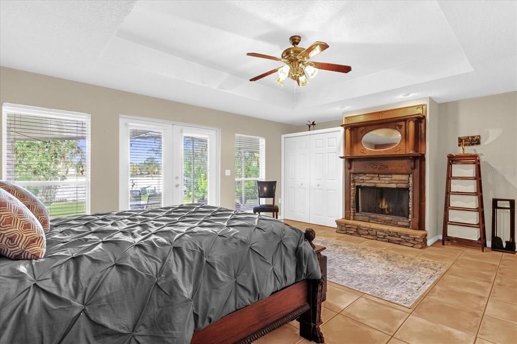 Main primary bedroom with views of Lake Arnold and fireplace