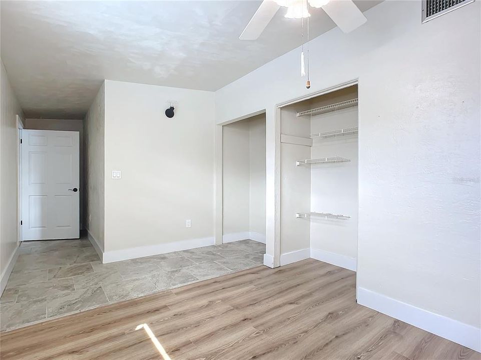 combination tile and luxury vinyl flooring in main bedroom