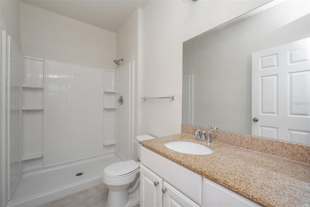 ensuite bathroom with stone countertop