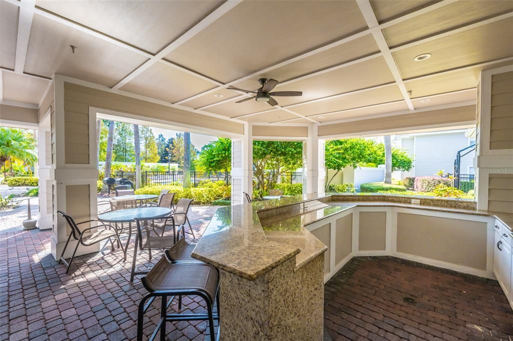 Outdoor kitchen including charcoal grills, mini bar fridge, sink & vending machine.