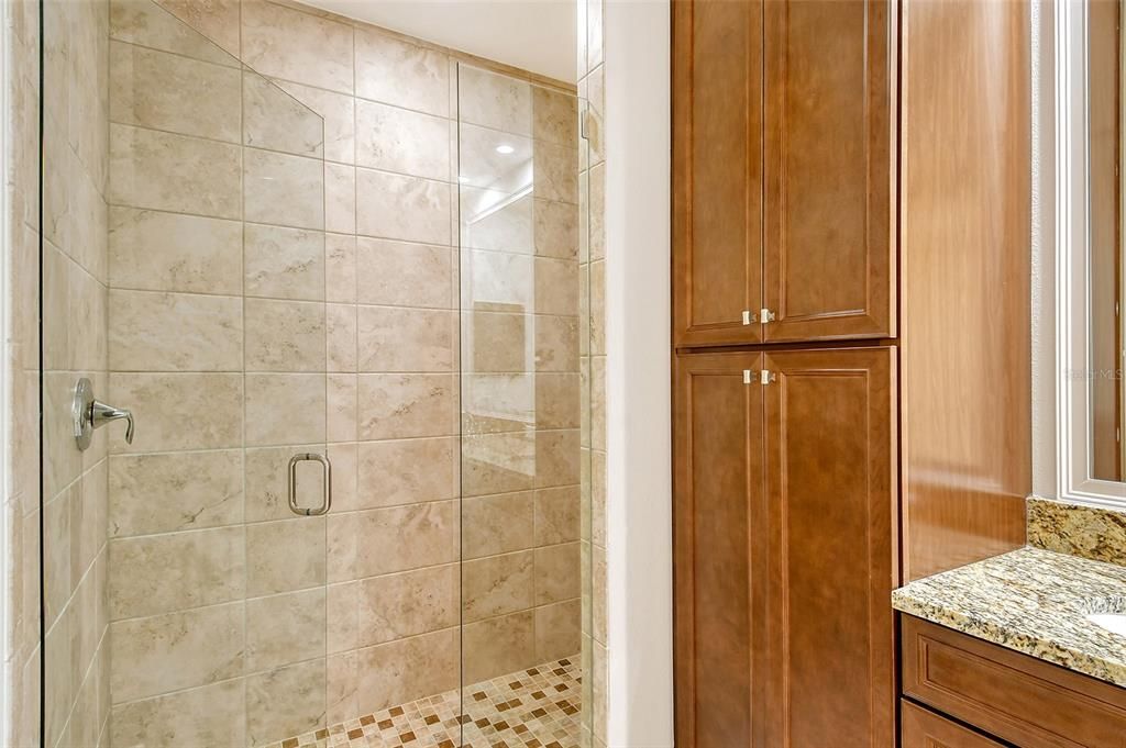 Solid wood cabinetry and glass shower doors.