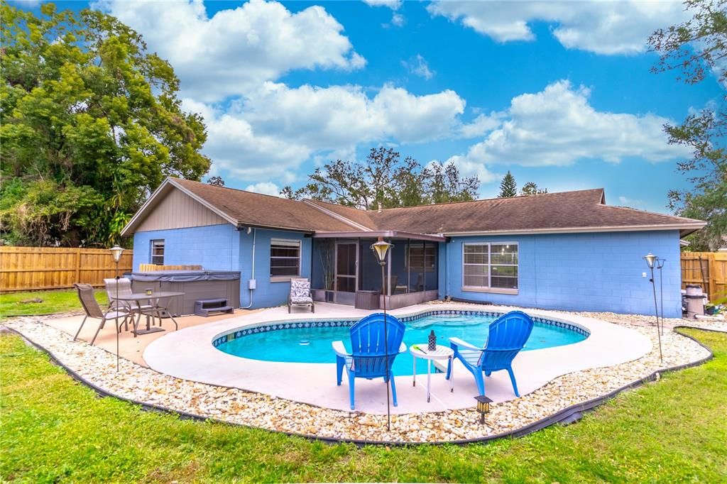 Fully fenced backyard oasis with a sparkling pool and relaxing hot tub.