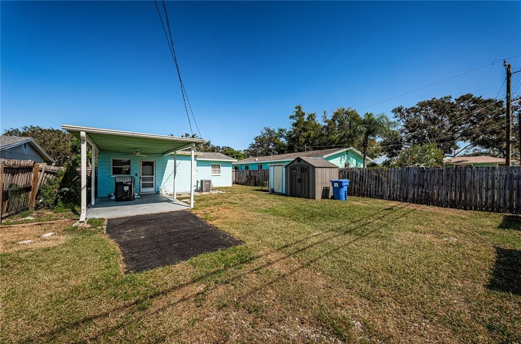 Backyard carport, blue shed conveys with home