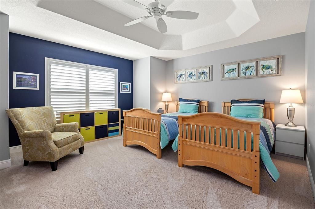 A large guest bedroom at the front of the home also features a tray ceiling and a double-door closet.