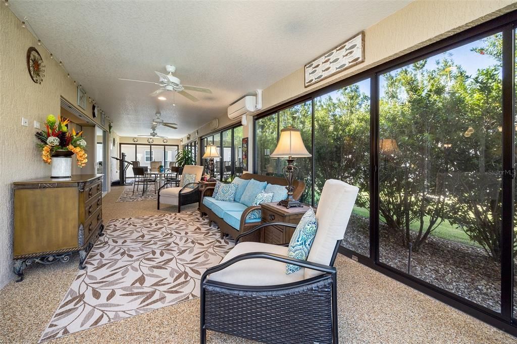 Step through the expansive sliding glass doors leads to an ENCLOSED LANAI with mini split unit featuring Chattahoochee River Rock, stretching along the entire back of the home.