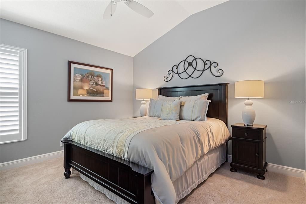 guest bedroom with vaulted ceiling offers ample space with a closet for your guests.