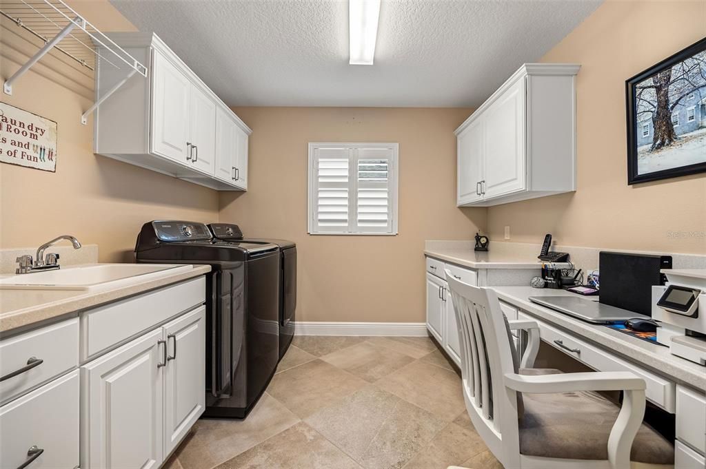 The home includes a large interior laundry room with matching cabinetry and a built-in desk.