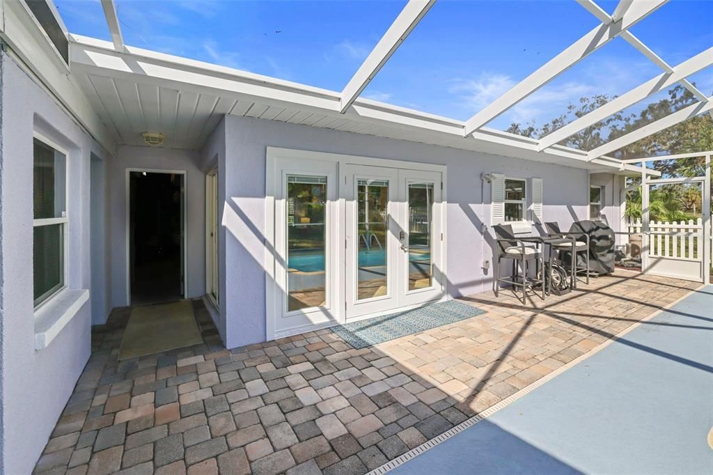 Pavers surround the pool and the large screened and covered lanai