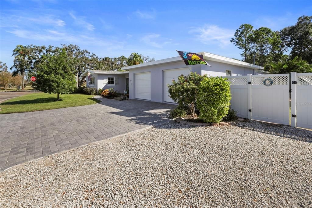 Brand New Paver Driveway, Parking extends to the white rocks, and through the fence is the one of the entrances to bedroom 3