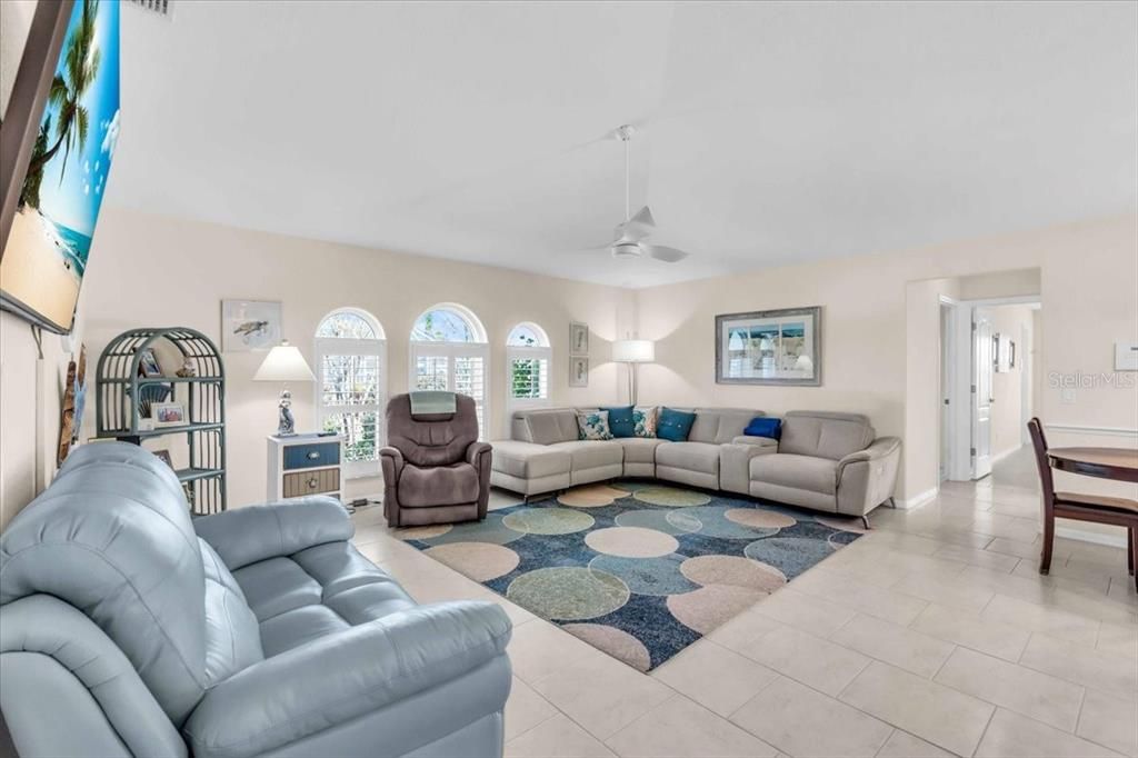 a spacious family room with newly installed impact windows. These windows reduce sound and are more energy efficient as well as being safe.