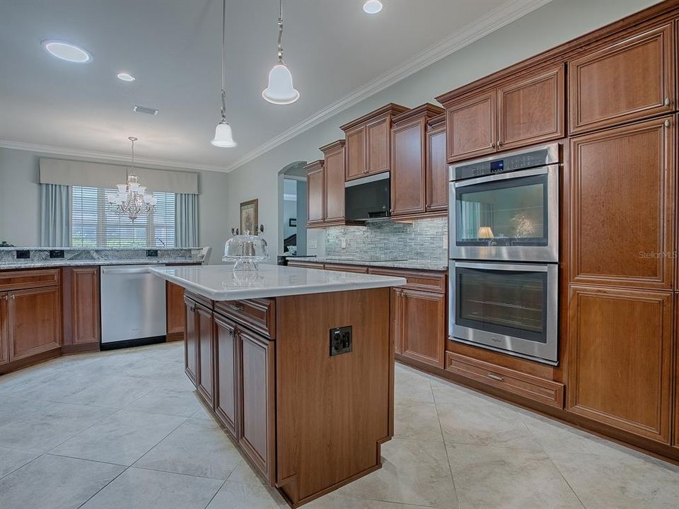 ISLAND WITH OVERHANG FOR BARSTOOL SEATING AND CONVENIENT ELECTRICAL. DOUBLE WALL OVENS WITH CLOSET PANTRY ON THE RIGHT WITH PULL OUT SHELVING.