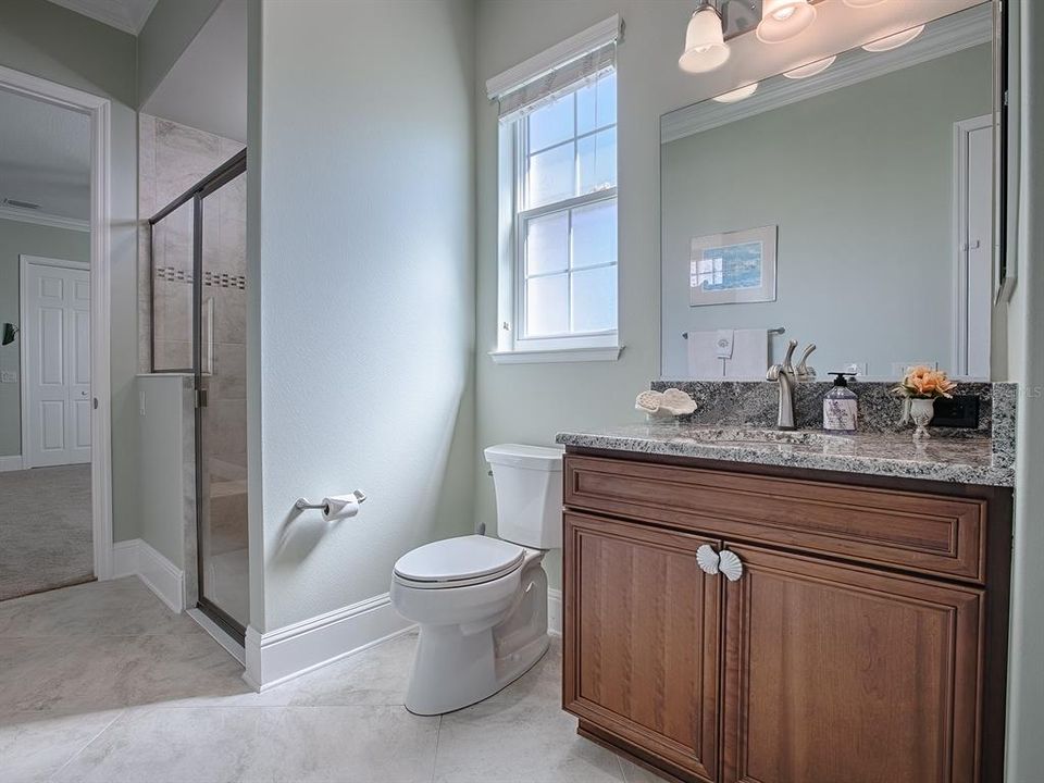 EN-SUITE BATH WITH GRANITE COUNTERS AND TILED SHOWER.