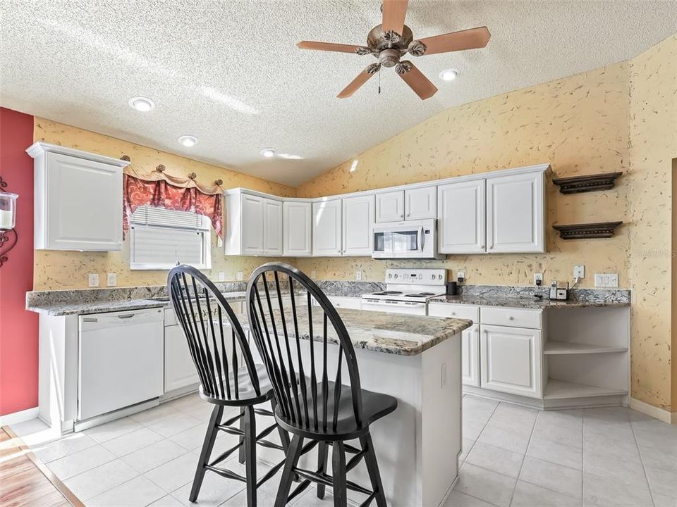 Kitchen - note the volume ceiling, center island and granite counters