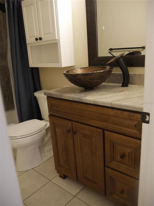 Full bath has a new toilet, vanity, vessel sink and faucet, new shower, tub, and sink fixtures, along with new lighting, mirror, and the very exotic granite from the kitchen!