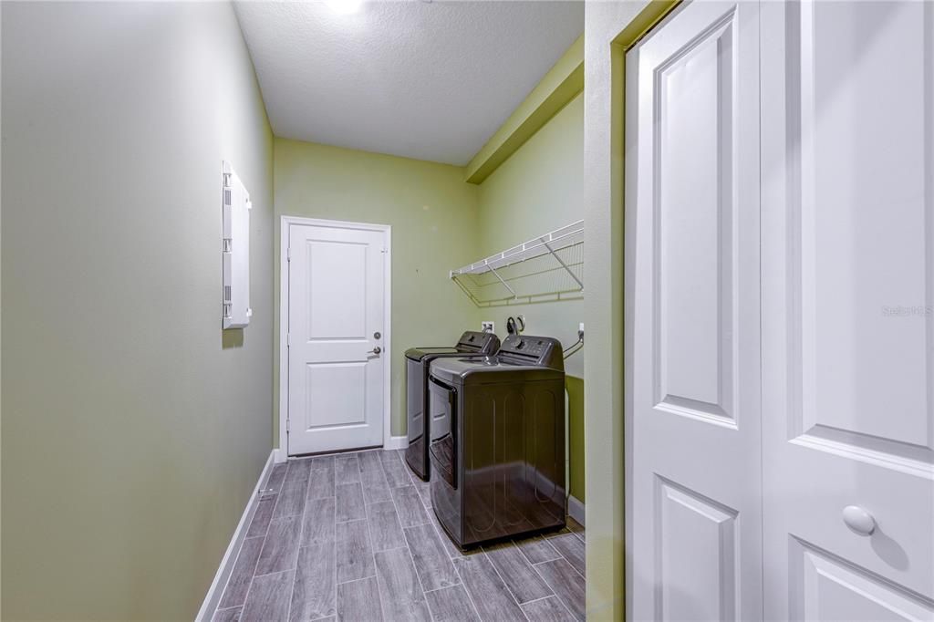 Indoor Laundry room has shelving and the washer and dryer are included