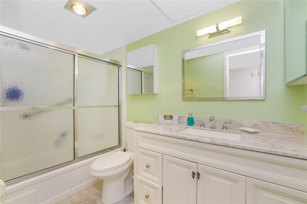 Light and bright bathroom with a shower/tub combo.