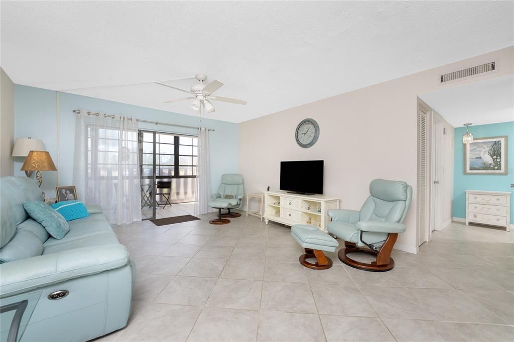 The living area features sliding glass door to the enclosed lanai.