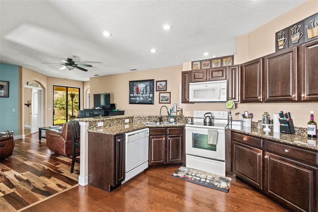 Large kitchen with wood cabinetry, hardwood flooring throughout the main living areas & breakfast bar.