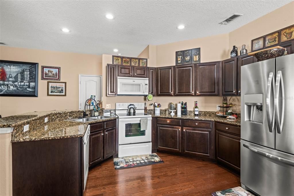 The kitchen features granite countertops, breakfast bar, & tons of counter space.