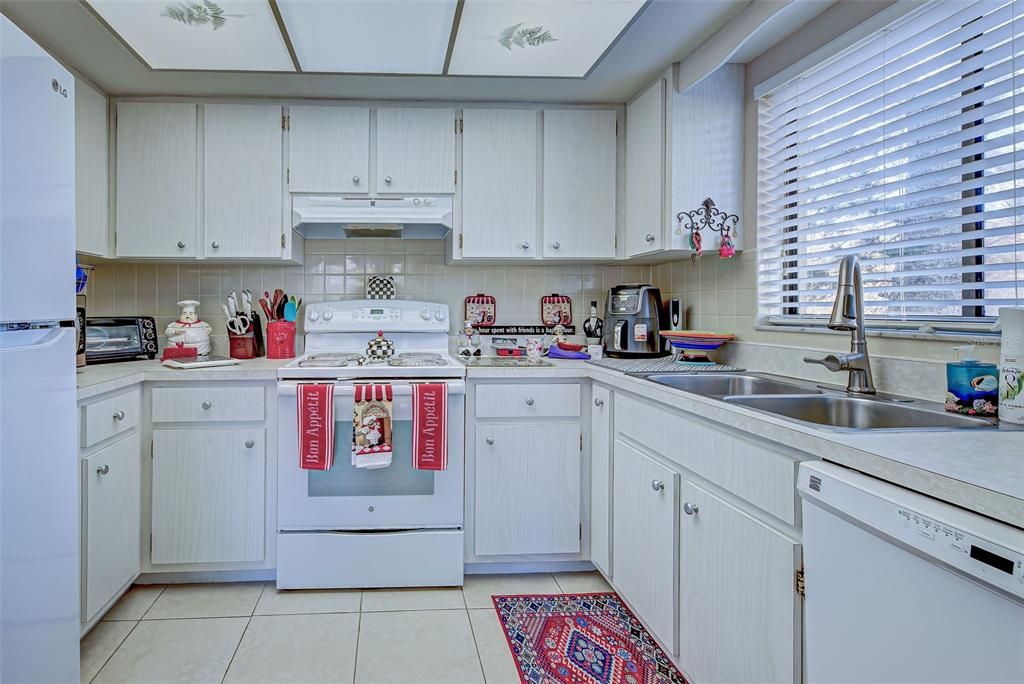 KITCHEN IS WELL EQUIPPED WITH LOADS OF CABINETS AND COUNTER SPACE.