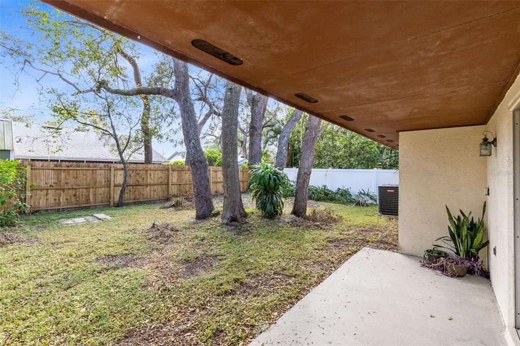 Step outside to the covered lanai that overlooks a sprawling backyard.