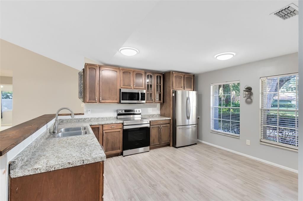 The eat-in kitchen is a delight, equipped with a breakfast bar for additional seating, stainless steel appliances, and a spacious walk-in pantry.