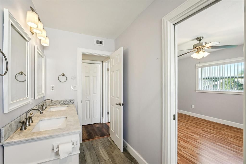 primary bathroom with pocket door to primary bedroom as well as hallway