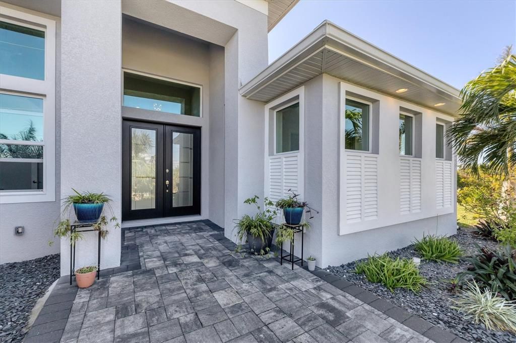 Elegant front entry featuring a grand entrance and mature landscaping