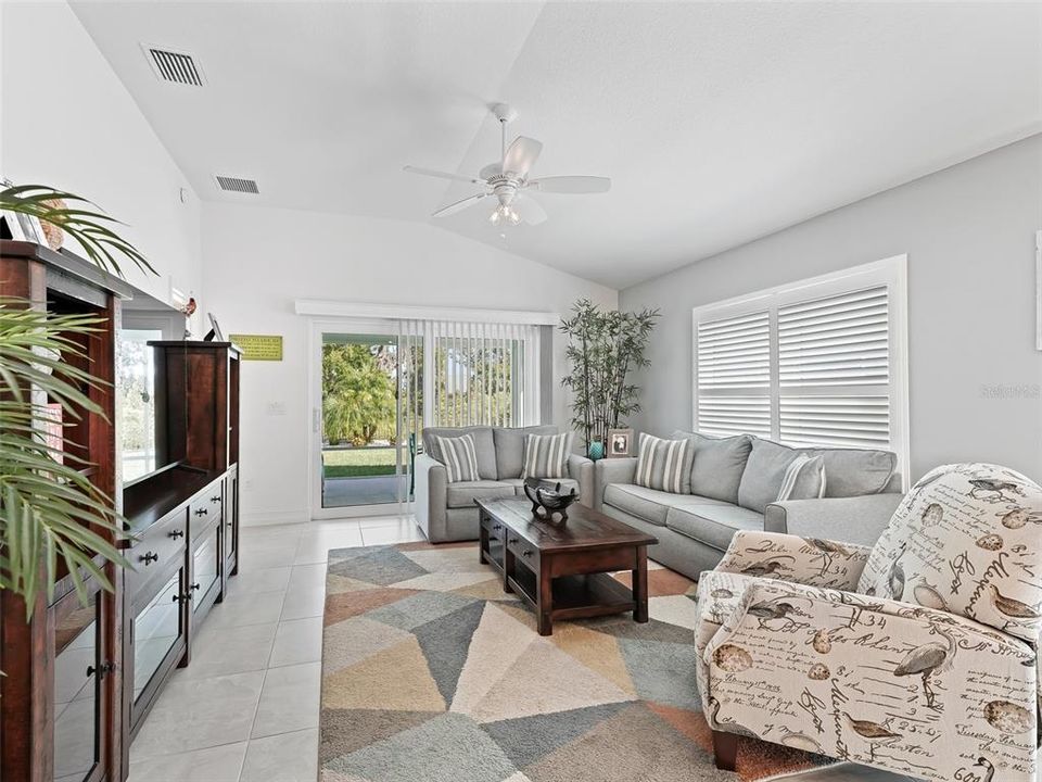 Living Room featuring Vaulted Ceilings and Sliding Glass Doors leading out to the private, Screened-in Lanai.