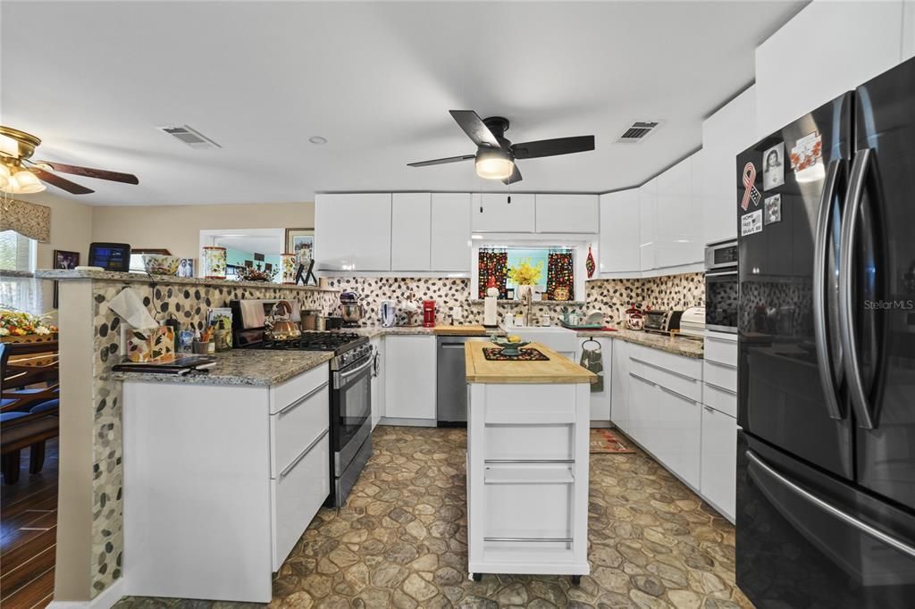 Kitchen with custom Cabinets, flooring and gas stove.