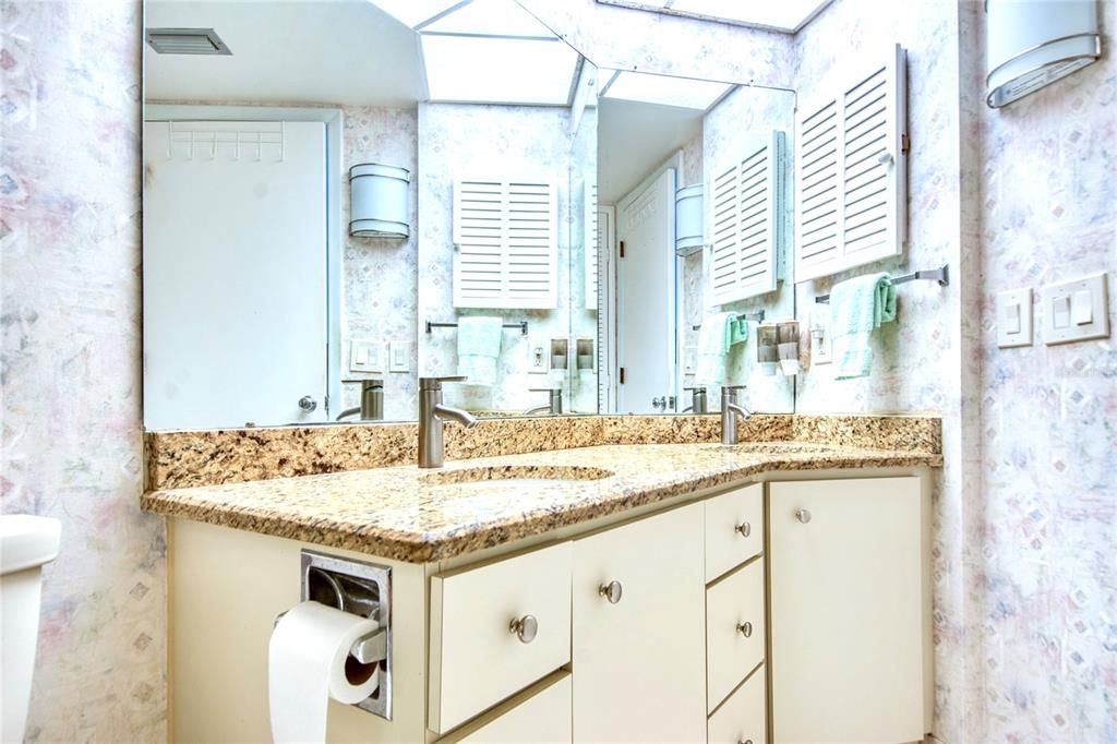 Dual sinks and tub/shower combo in primary bathroom suite.