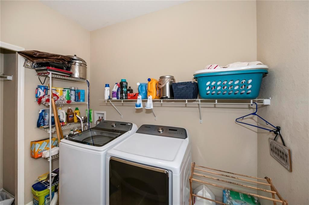 Convenient spacious laundry room right off the kitchen also allows for extra storage area.