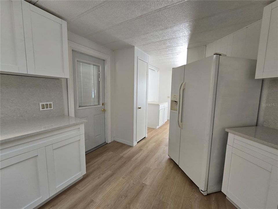 View in kitchen towards outside door and pantry