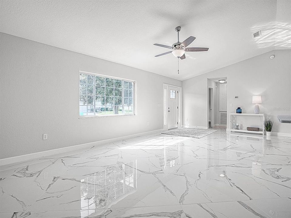 Bright & Airy Living Room featuring stunning 32" Porcelain Tile layer on the diagonal, Vaulted Ceilings and New Paint