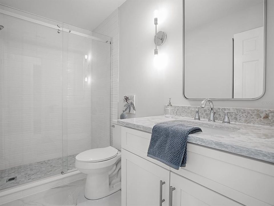 Guest Bath featuring a Custom Tile Walk-in shower with Frameless Shower Doors, New White Shaker Vanity with Quartz Countertop